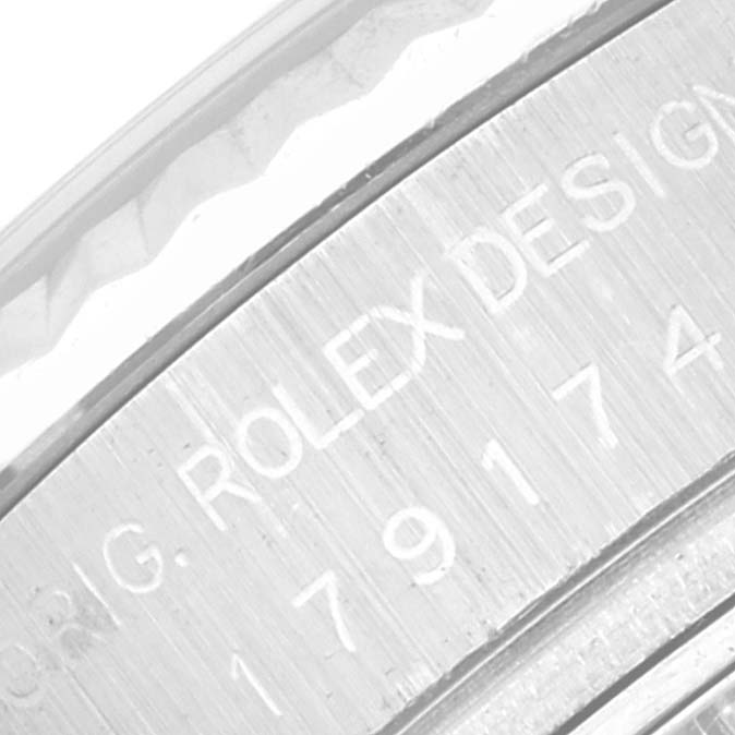 This close-up image shows the engraved text on the metal surface of the bezel and case of a Rolex Datejust 179174 Women's Stainless Steel Black Dial 179174 Women's Stainless Steel Black Dial watch.