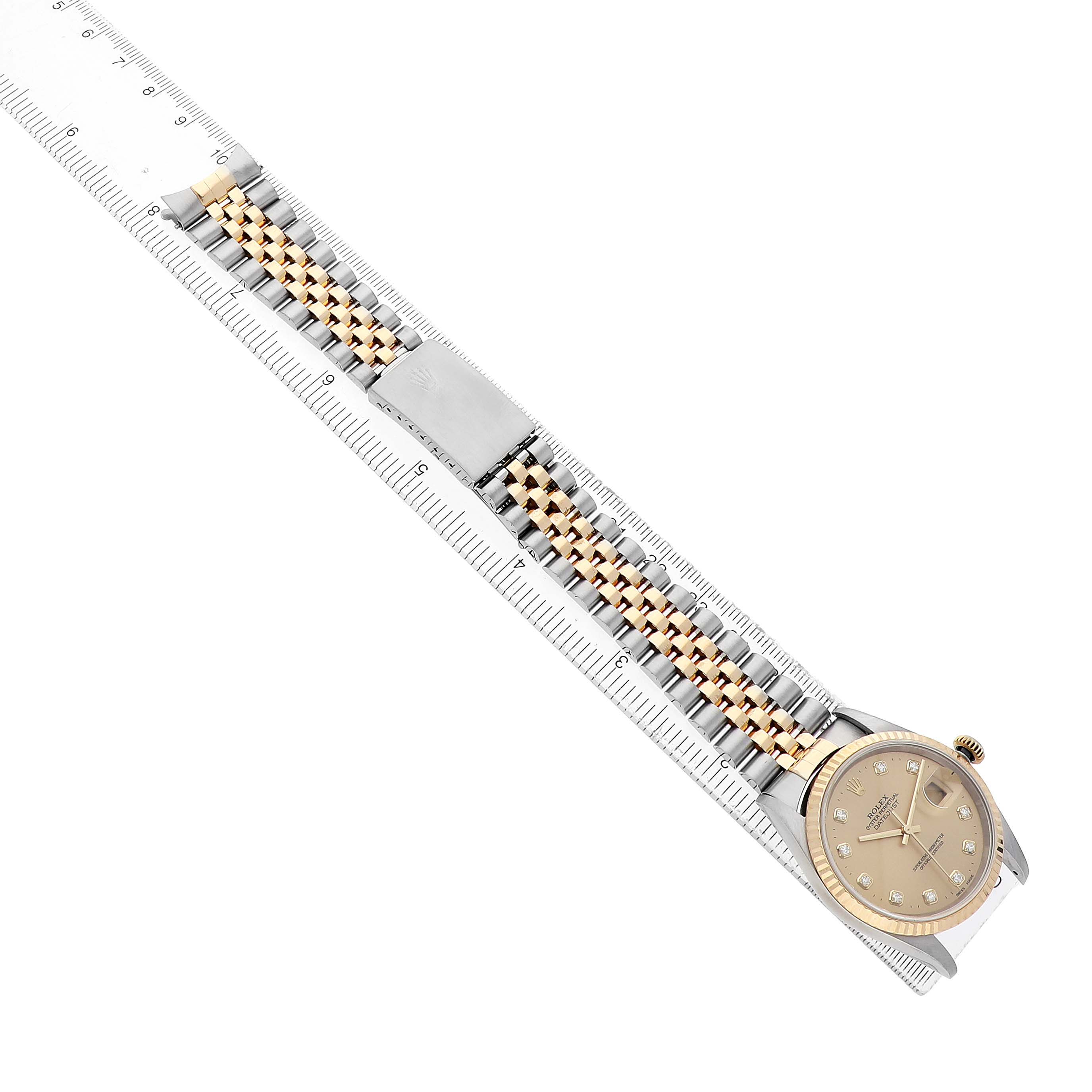 The Rolex Datejust 16233 Men's Steel and Gold (two tone) Champagne Dial watch is shown from a top view, displaying the full face and the linked bracelet alongside a ruler.