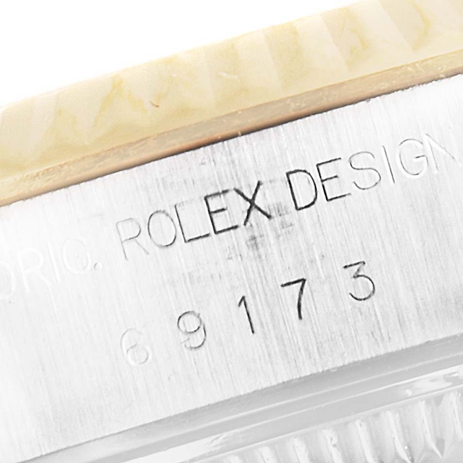 This image shows a close-up of the engraved serial number and "Rolex Design" text on the case of a Rolex Datejust 69173 Women's Steel and Gold (two tone) Champagne Dial 69173 Women's Steel and Gold (two tone) Champagne Dial watch.