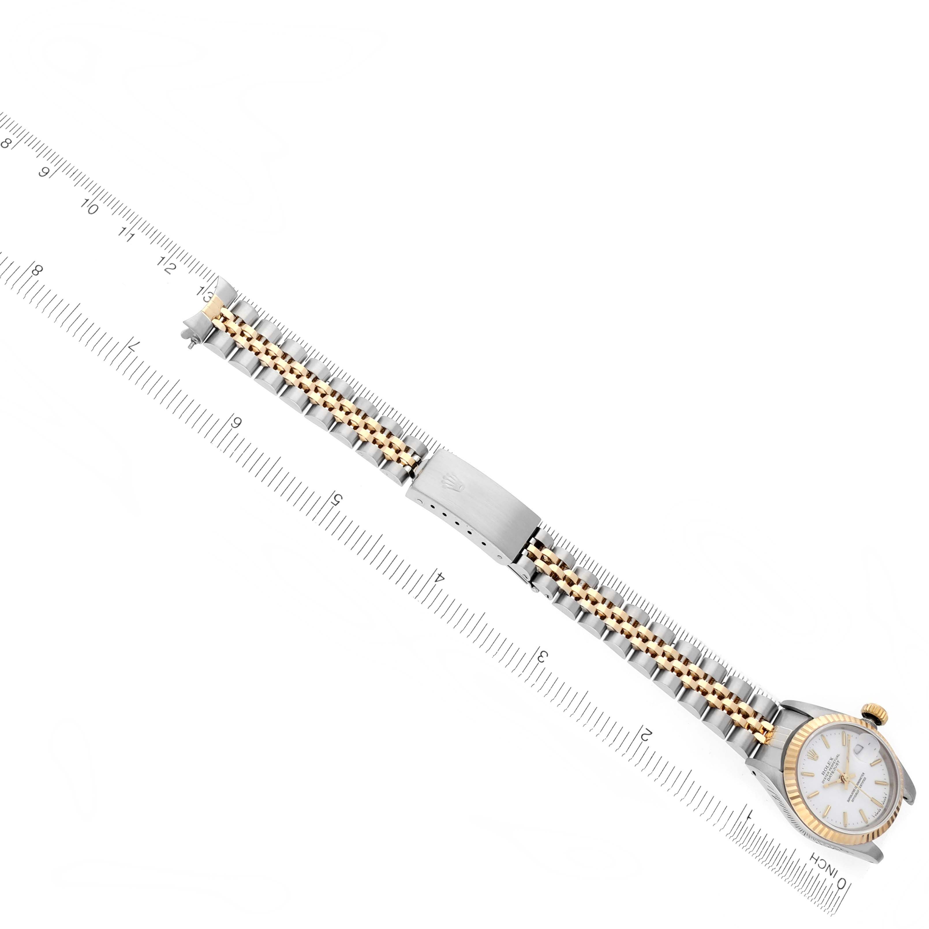 The image shows a Rolex Datejust 69173 Women's Steel and Gold (two tone) White Dial 69173 Women's Steel and Gold (two tone) White Dial watch from a top-down angle, highlighting the face, bezel, crown, and bracelet laid out with a ruler.