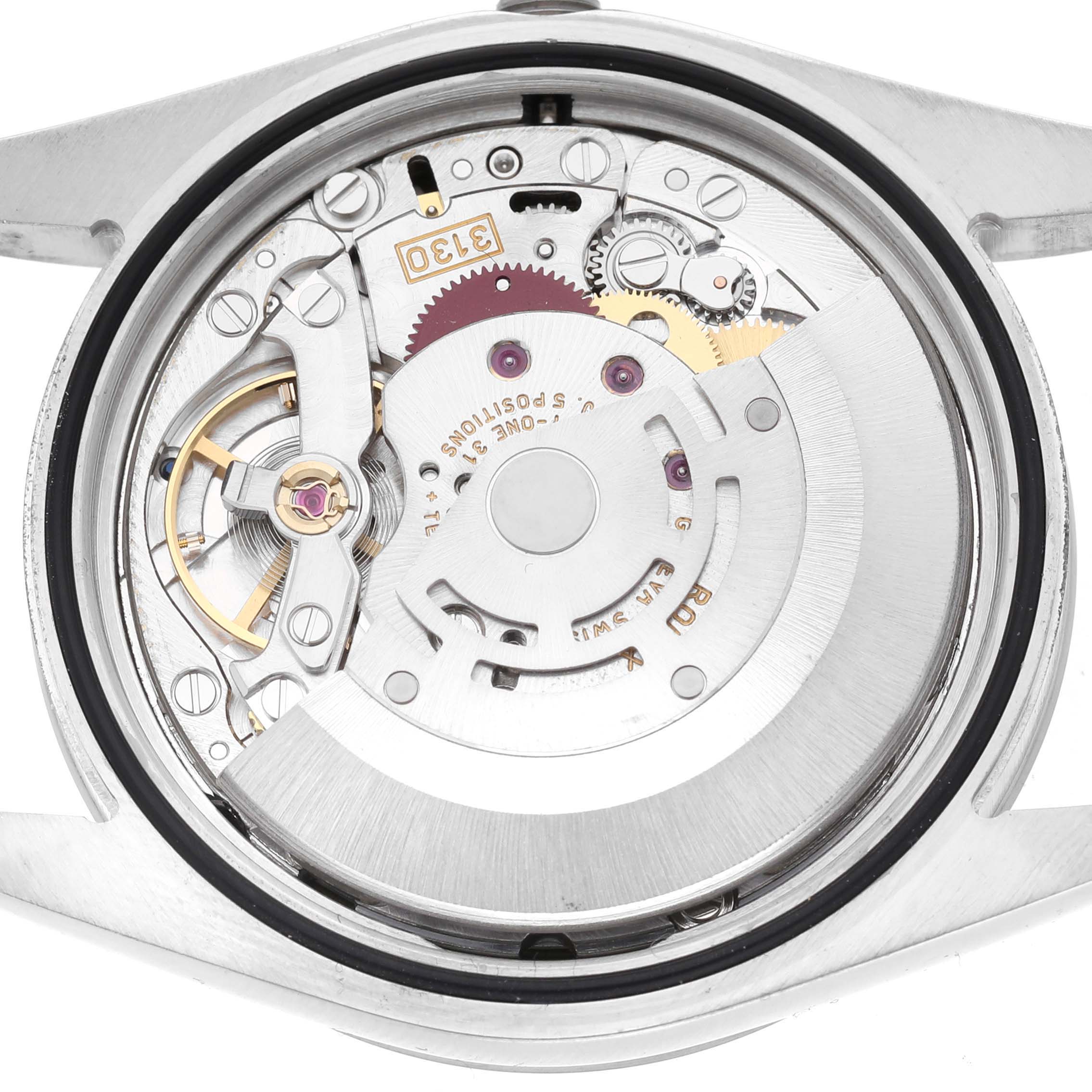 The image shows the movement mechanism of a Rolex Explorer 114270 Men's Stainless Steel Black Dial model, viewed from the back with visible gears and rotor.