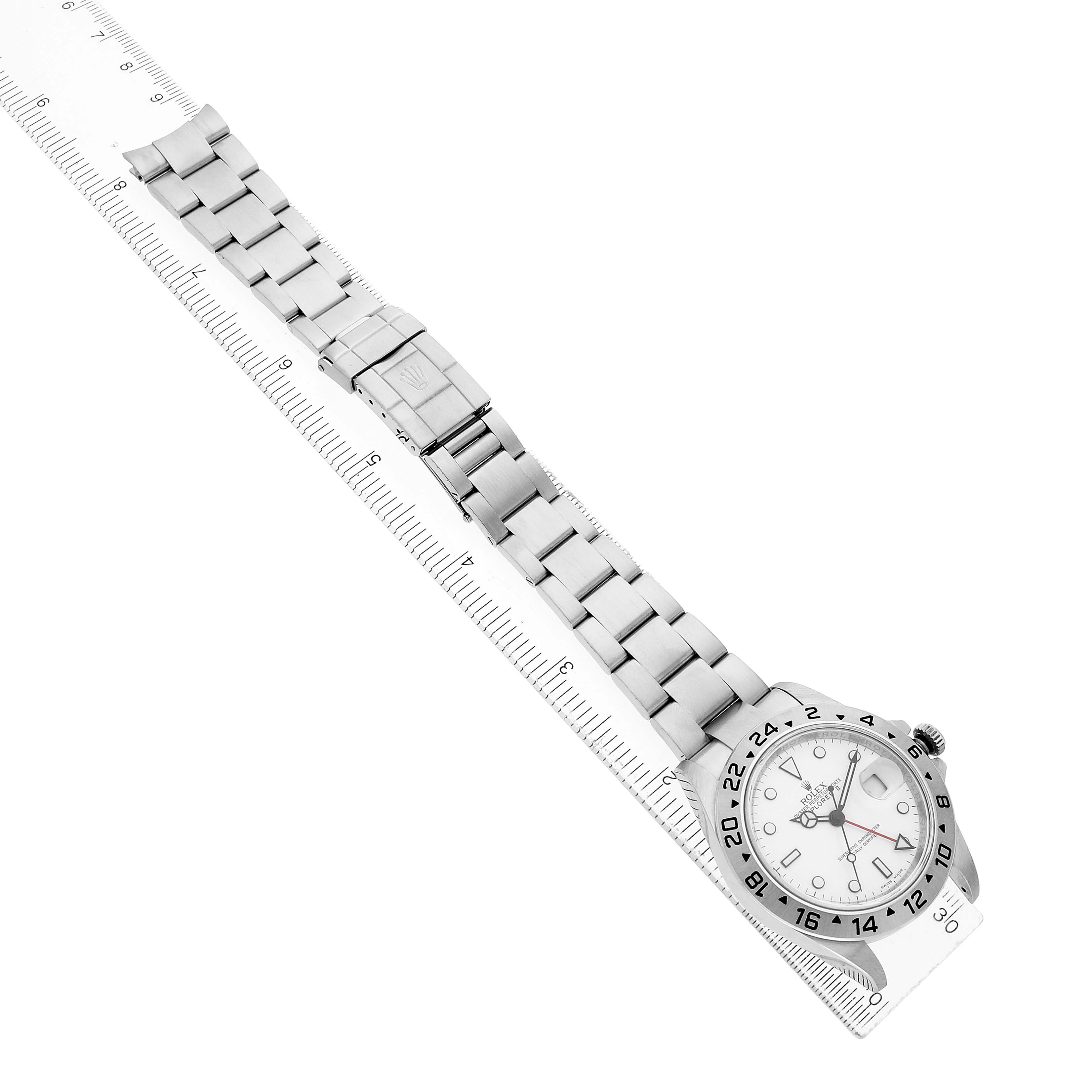 The Rolex Explorer 16570 Men's Stainless Steel White Dial watch is shown at an angle with the bracelet extended, displaying the dial and clasp alongside a ruler for scale.