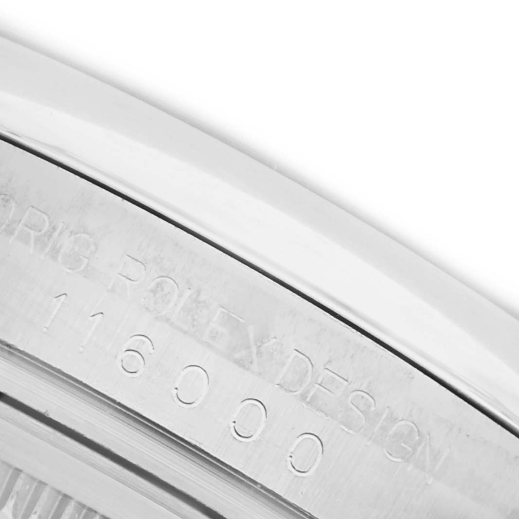 The image shows a close-up of the engraving on the side of a Rolex Oyster Perpetual 116000 Men
s Stainless Steel Black Dial 116000 Men
s Stainless Steel Black Dial watch case, featuring its model number.