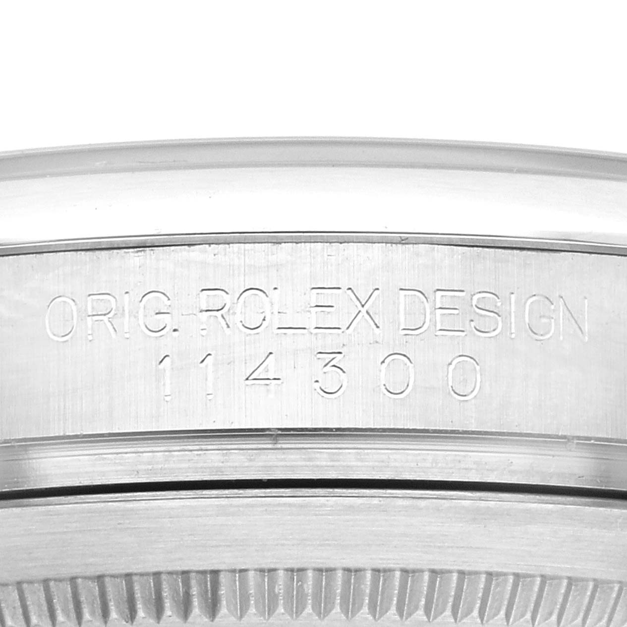 This image shows a close-up of the bezel on a Rolex Oyster Perpetual 114300 Men
s Stainless Steel Black Dial 114300 Men
s Stainless Steel Black Dial, highlighting the "ORIG. ROLEX DESIGN" engraving and model number 114300.