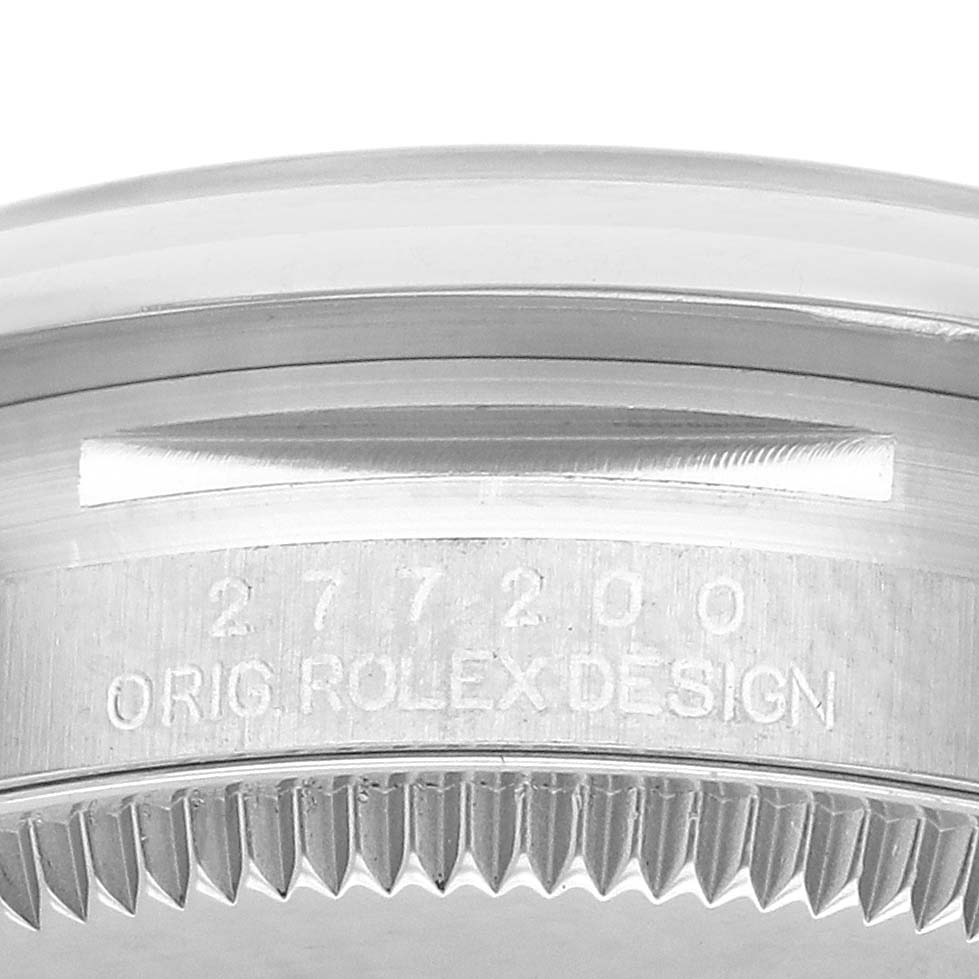 The image shows a close-up of the side of a Rolex Oyster Perpetual 277200 Women's Stainless Steel Blue Dial watch, highlighting the engraved serial number and design text.