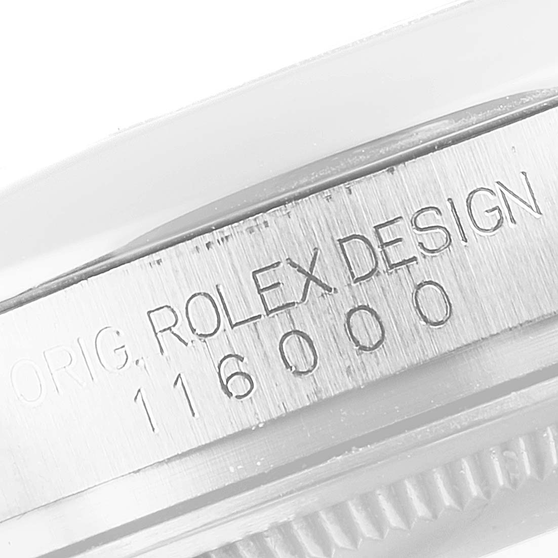 This close-up image shows the engraved serial number on the side of the Rolex Oyster Perpetual 116000 Men's Stainless Steel Grey Dial 116000 Men's Stainless Steel Grey Dial model.