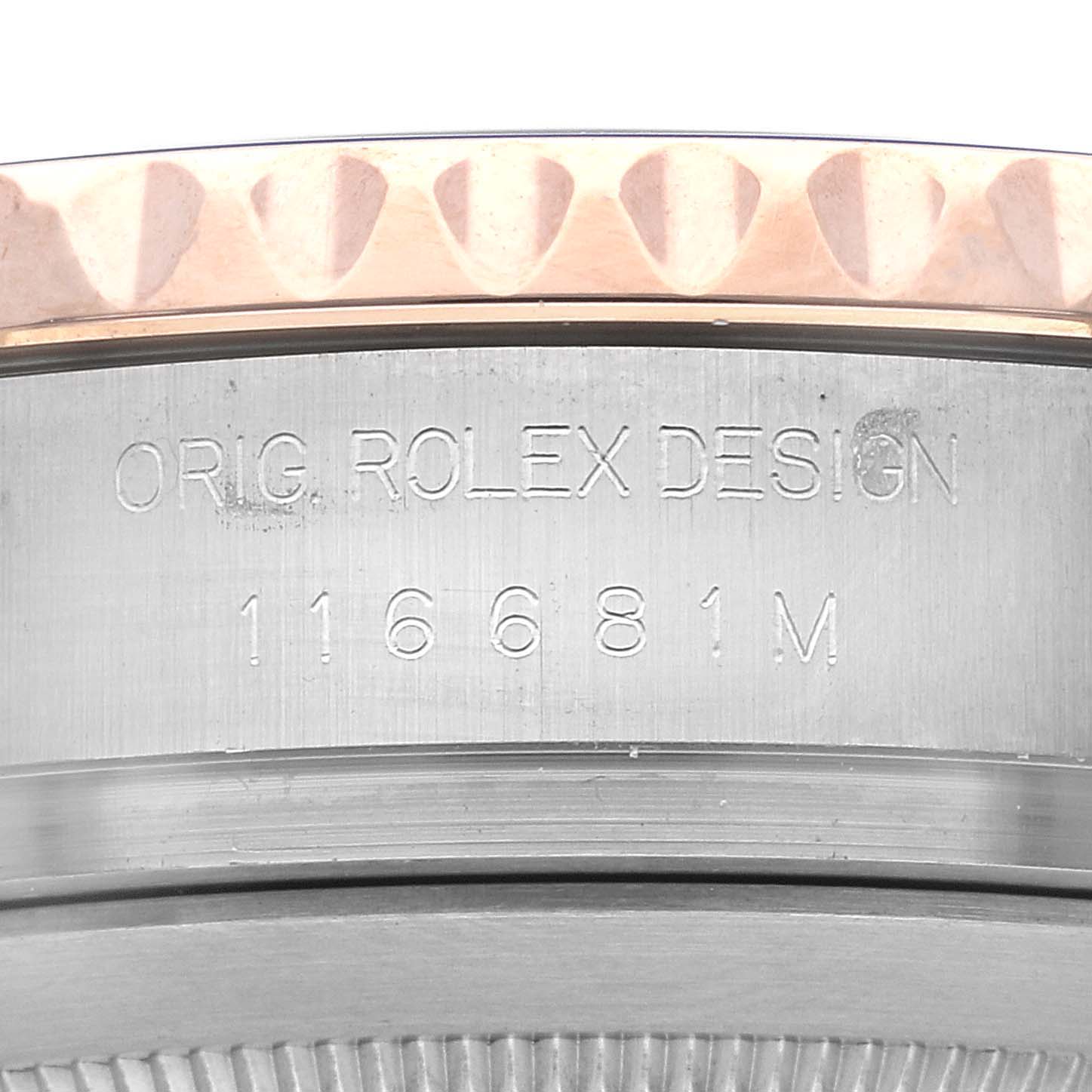 This image shows an angled close-up of the engraved case side of a Rolex Yacht-Master 116681 Men's Steel and Gold (two tone) White Dial 116681 Men's Steel and Gold (two tone) White Dial watch, including part of the bezel.