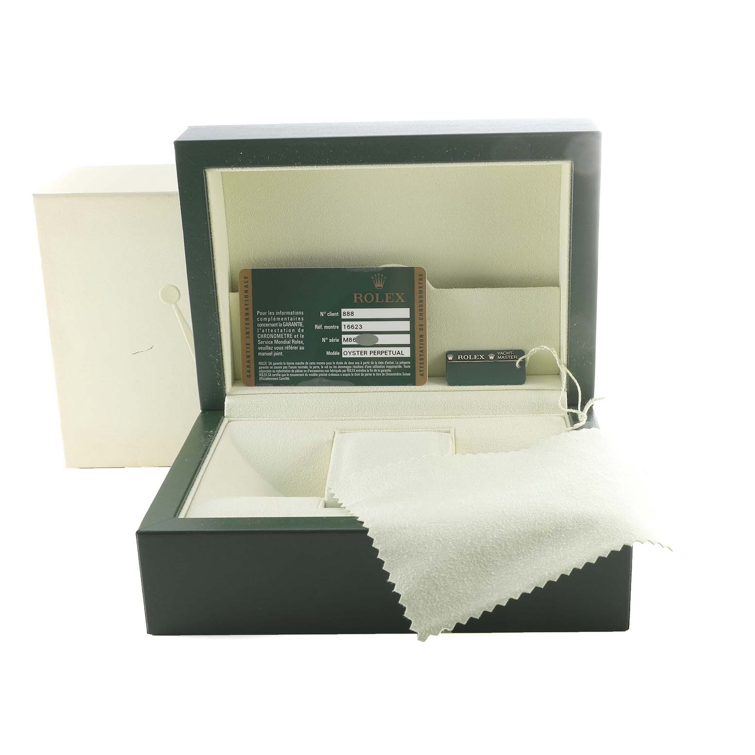 The image shows an open Rolex box for a Yacht-Master model, including a warranty card, hang tag, and cleaning cloth.