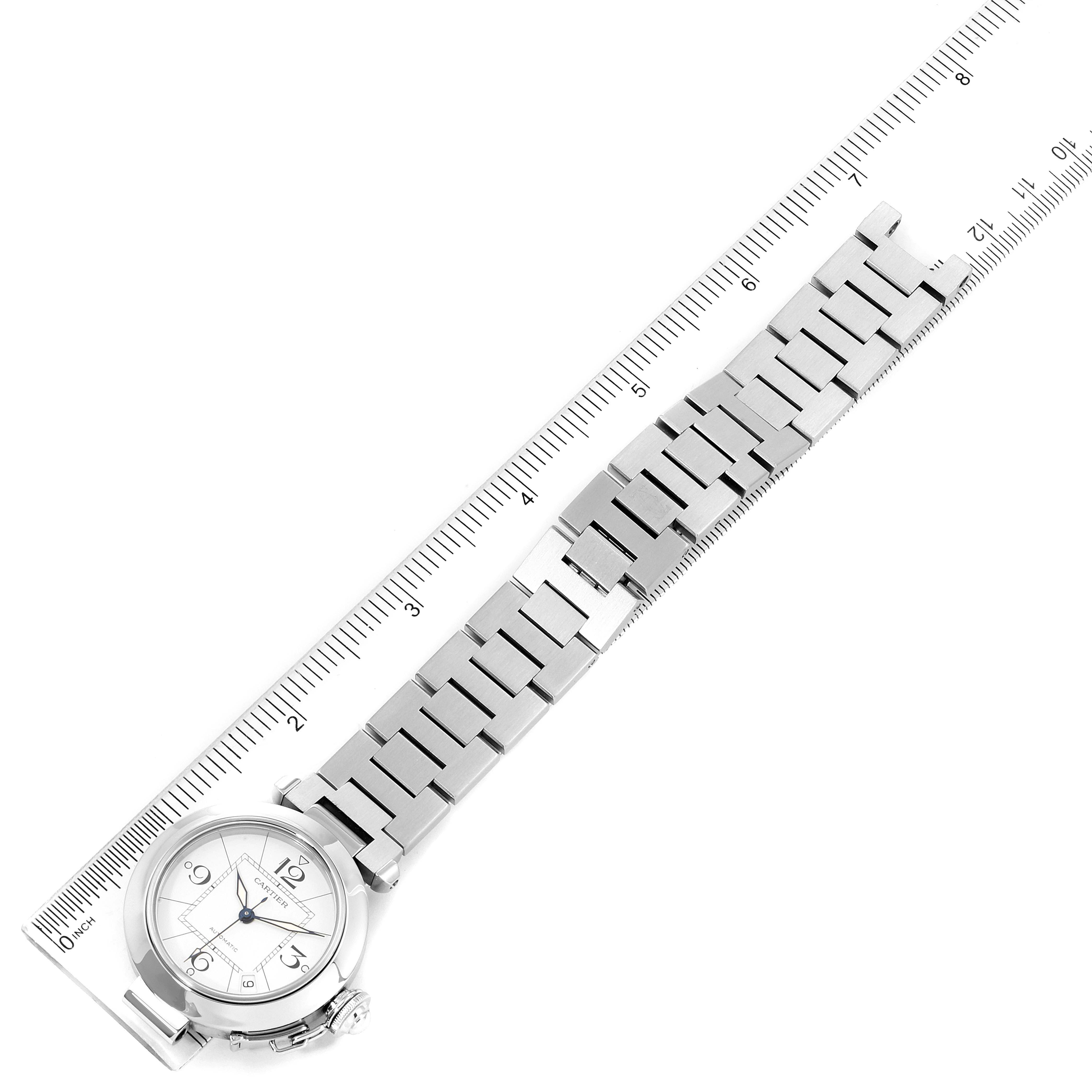 The image shows a Cartier Pasha W31074M7 Men's Stainless Steel White Dial W31074M7 Men's Stainless Steel White Dial watch laying flat, displaying the face, bracelet, and ruler to measure its length.