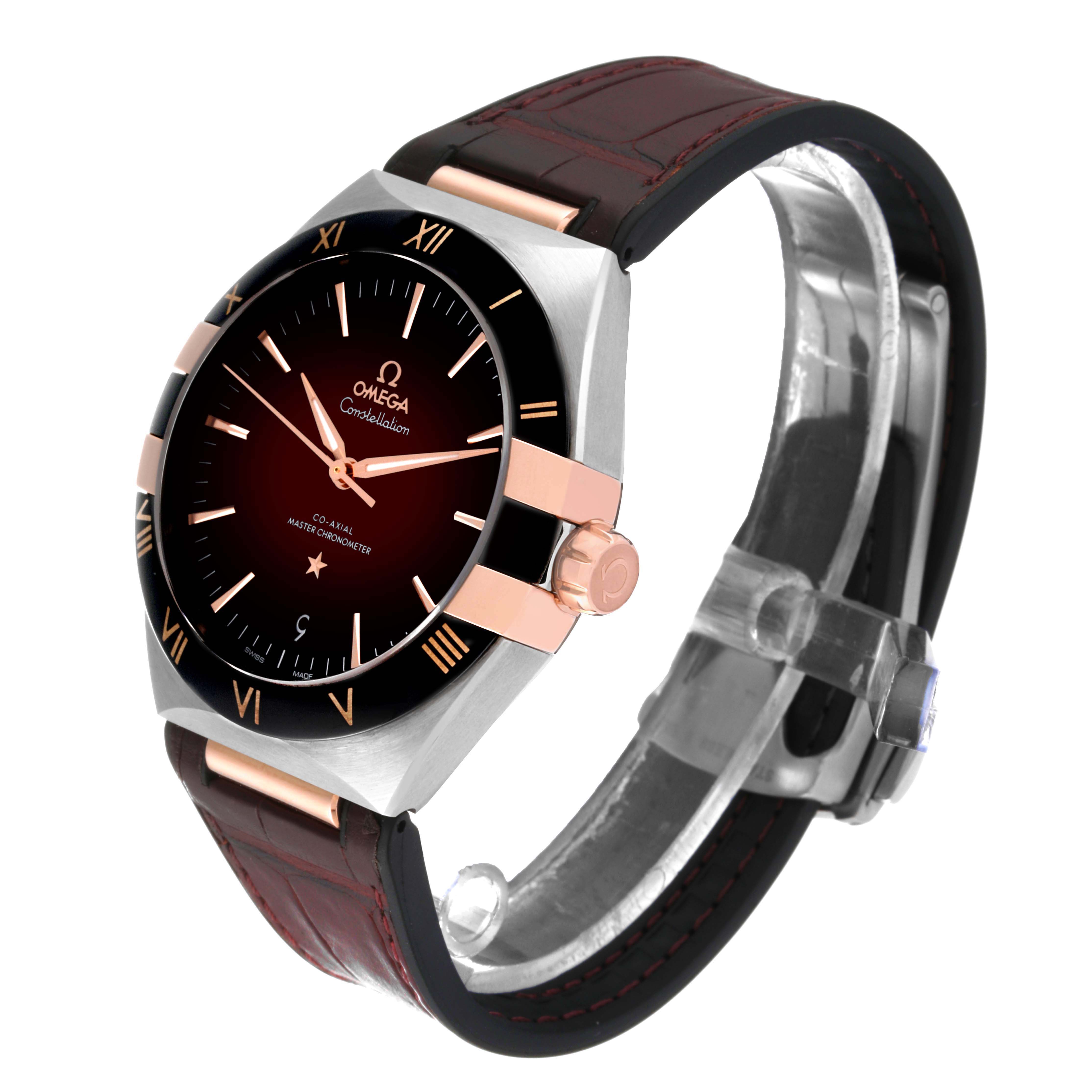 The image shows an angled view of an Omega Constellation 131.23.41.21.11.001 Men's Steel and Gold (two tone) Red Dial 131.23.41.21.11.001 Men's Steel and Gold (two tone) Red Dial watch, displaying its dial, bezel, case, crown, and leather strap.
