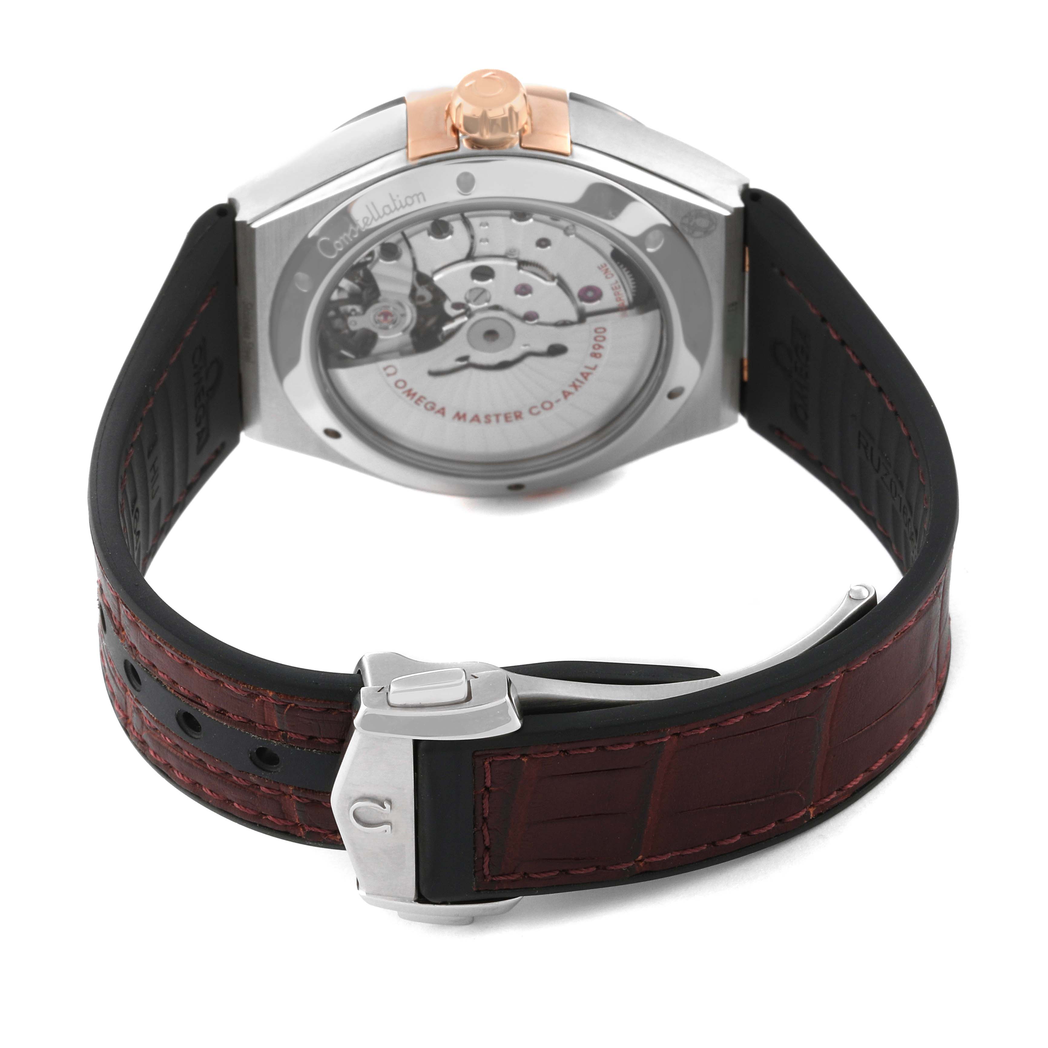 The image shows the back view of the Omega Constellation 131.23.41.21.11.001 Men's Steel and Gold (two tone) Red Dial 131.23.41.21.11.001 Men's Steel and Gold (two tone) Red Dial watch, highlighting its mechanism and brown strap.