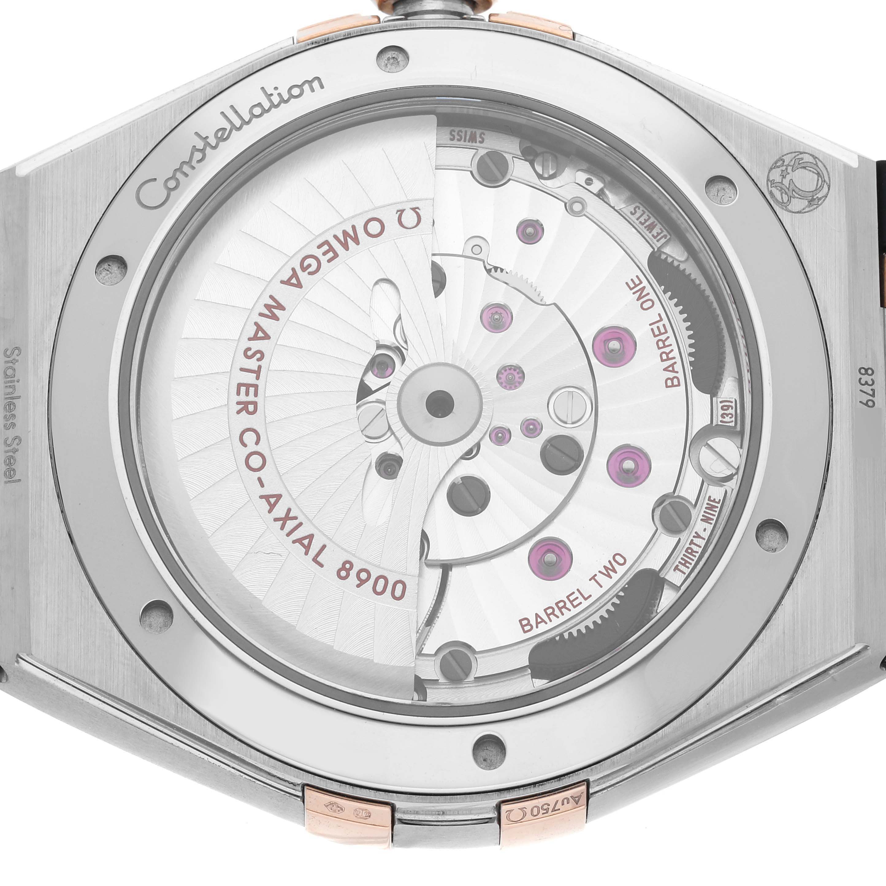 The image shows the case back of the Constellation model by Omega, highlighting the movement and inner mechanism.