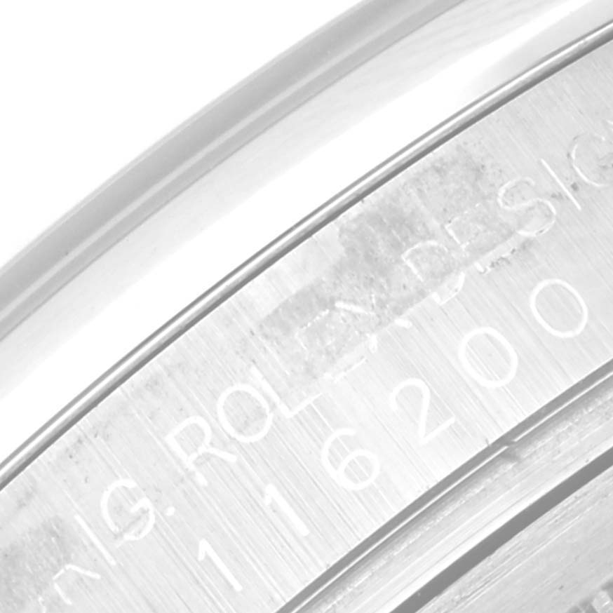 This close-up image shows part of the engraved bezel on a Rolex Datejust 116200 Men's Stainless Steel Pink Dial 116200 Men's Stainless Steel Pink Dial model watch.