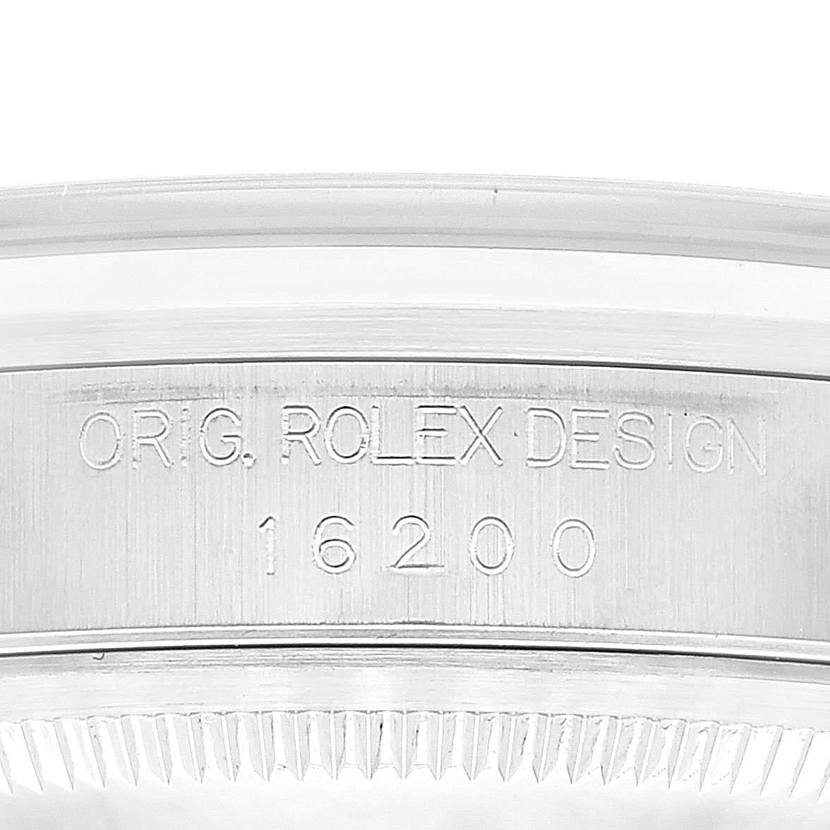 The image shows a close-up view of the side of a Datejust model Rolex watch, focusing on the engraved serial number and design text.