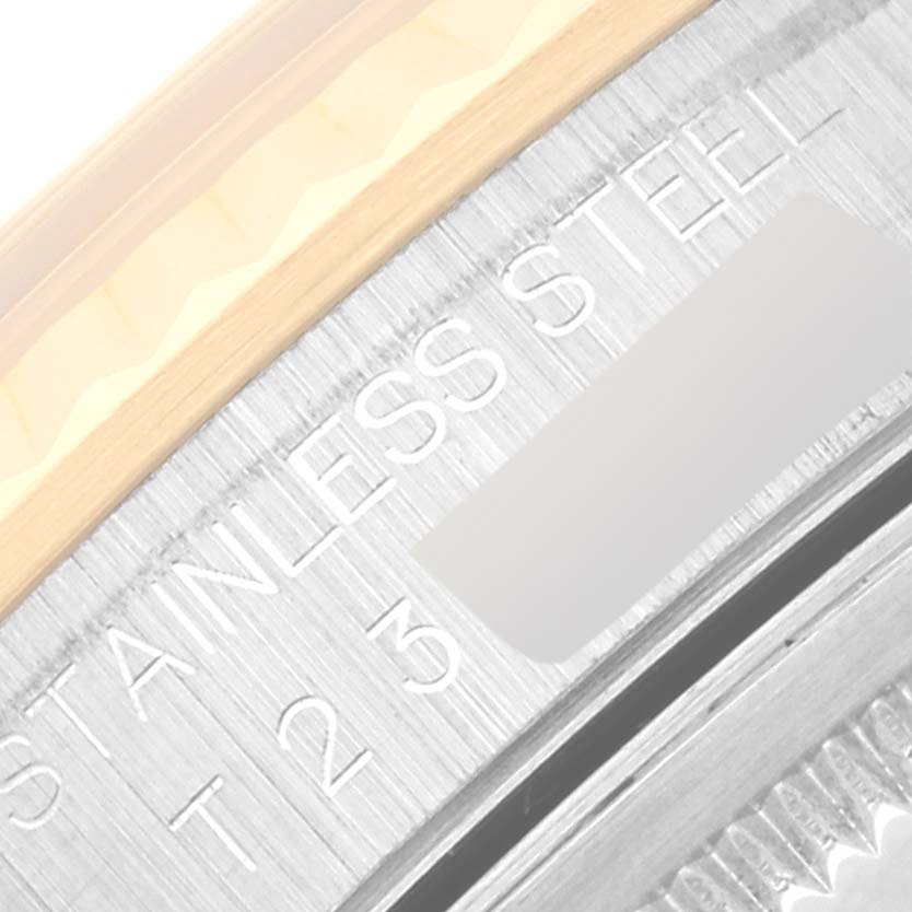 The image shows a close-up of the bezel and partly the case of a Rolex Datejust 16233 Men's Steel and Gold (two tone) Champagne Dial 16233 Men's Steel and Gold (two tone) Champagne Dial watch, revealing the "Stainless Steel" engraving.