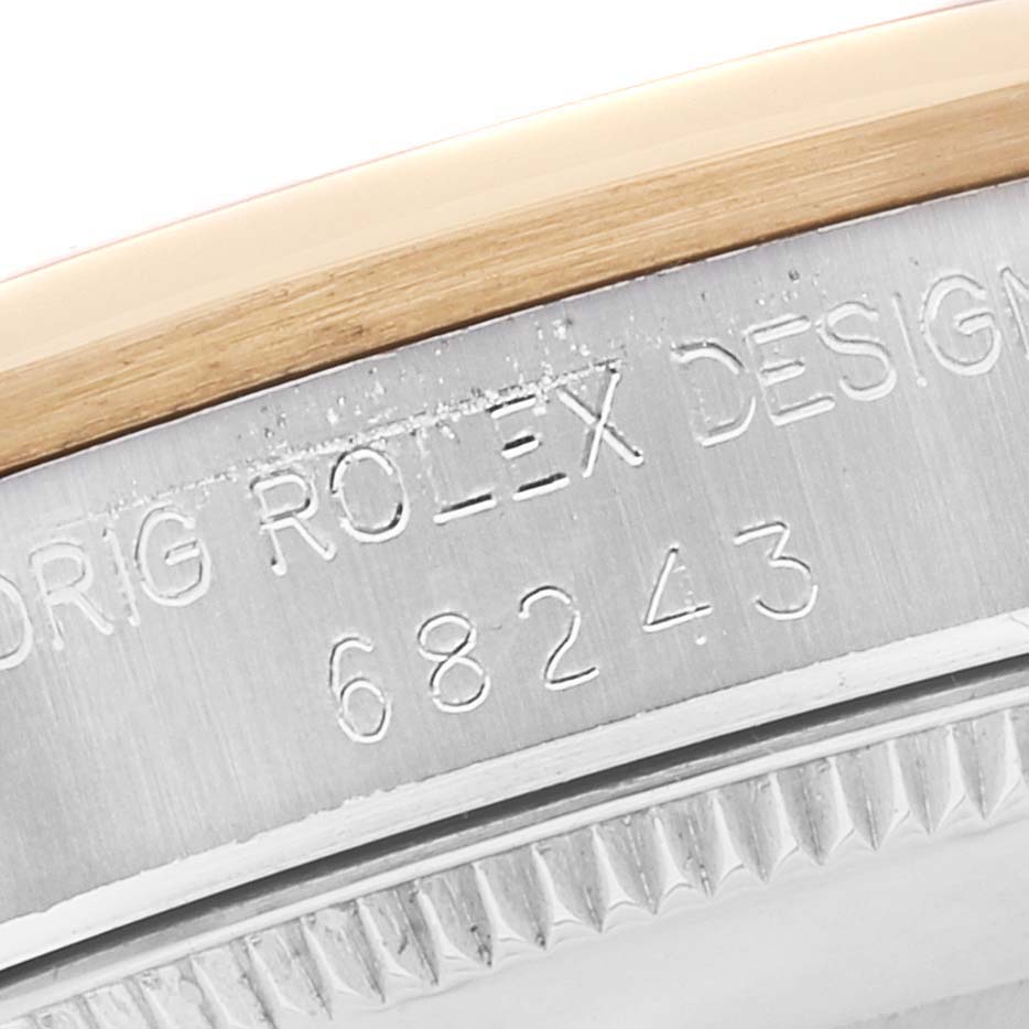 This close-up image shows the edge of the Rolex Mid-Size 68243 Women's Steel and Gold (two tone) White Dial 68243 Women's Steel and Gold (two tone) White Dial model, featuring the bezel and engraved model number.