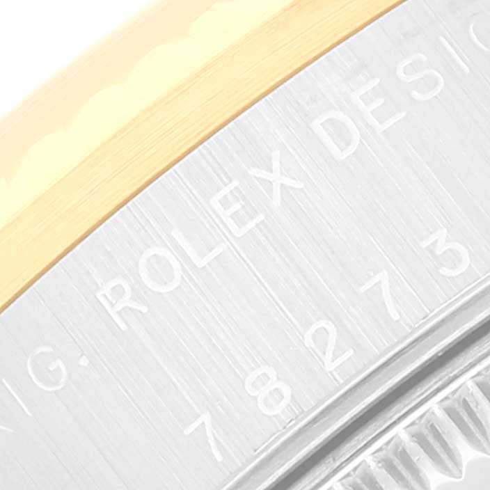 This close-up image shows the side of a Rolex Mid-Size 78273 Women
s Steel and Gold (two tone) Mother of Pearl Dial 78273 Women
s Steel and Gold (two tone) Mother of Pearl Dial watch, featuring the brushed metal finish and engraved text.