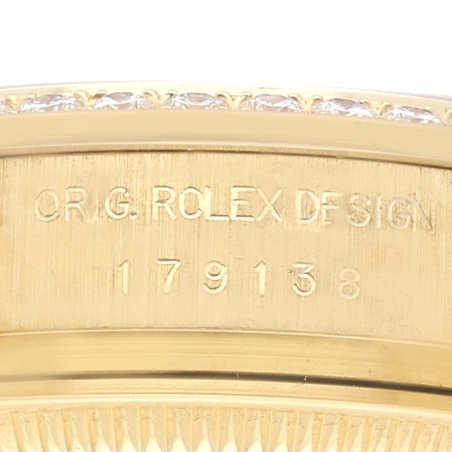 The image shows a close-up of the case side of the Rolex President 179138 Women's Yellow Gold Champagne Dial 179138 Women's Yellow Gold Champagne Dial model, highlighting its engraved serial number.
