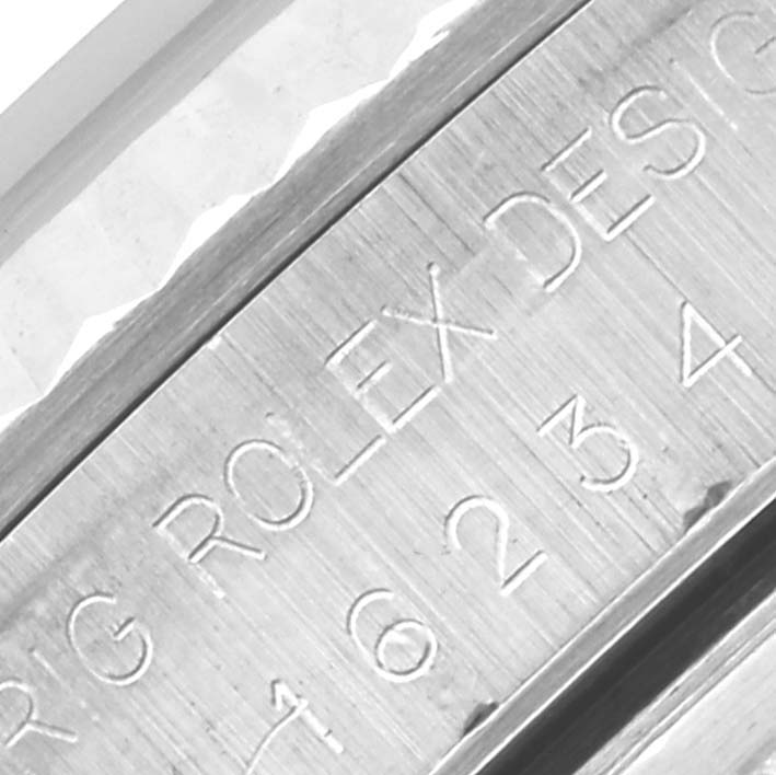 The image shows a close-up of the engraved bezel edge of a Rolex Datejust 16234 Men's Stainless Steel Beige Dial 16234 Men's Stainless Steel Beige Dial watch.