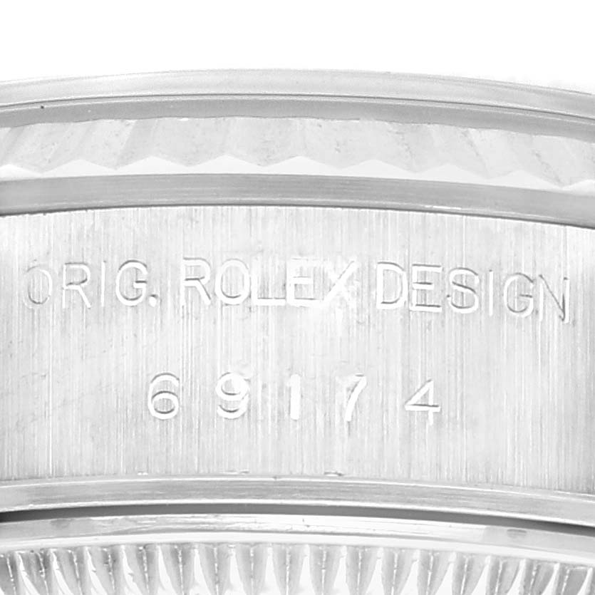 This image shows an up-close view of the engraved serial number and design details on the side of a Rolex Datejust 69174 Women's Stainless Steel Blue Dial 69174 Women's Stainless Steel Blue Dial watch case.