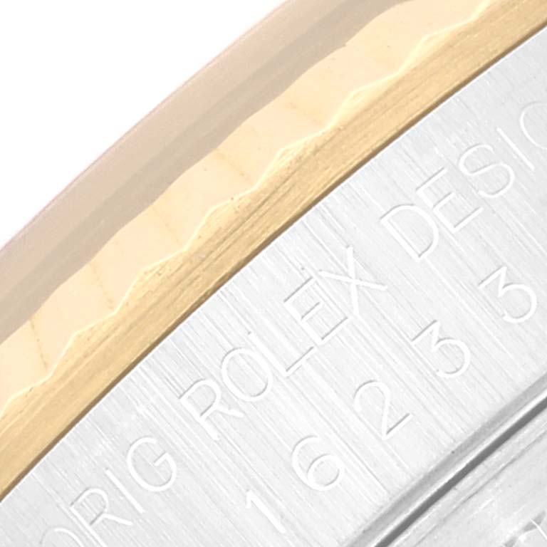This image shows a close-up of the bezel and engraved part of the case of a Rolex Datejust 16233 Men's Steel and Gold (two tone) Black Dial 16233 Men's Steel and Gold (two tone) Black Dial watch.
