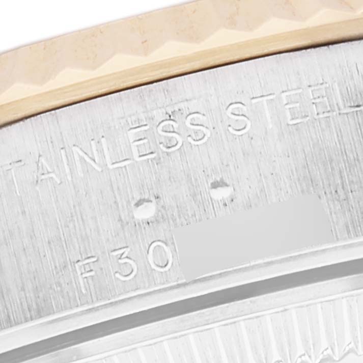 The image shows a close-up of the stainless steel and gold bezel of a Rolex Datejust 79173 Women's Steel and Gold (two tone) Champagne Dial 79173 Women's Steel and Gold (two tone) Champagne Dial watch, highlighting part of the engraved text.