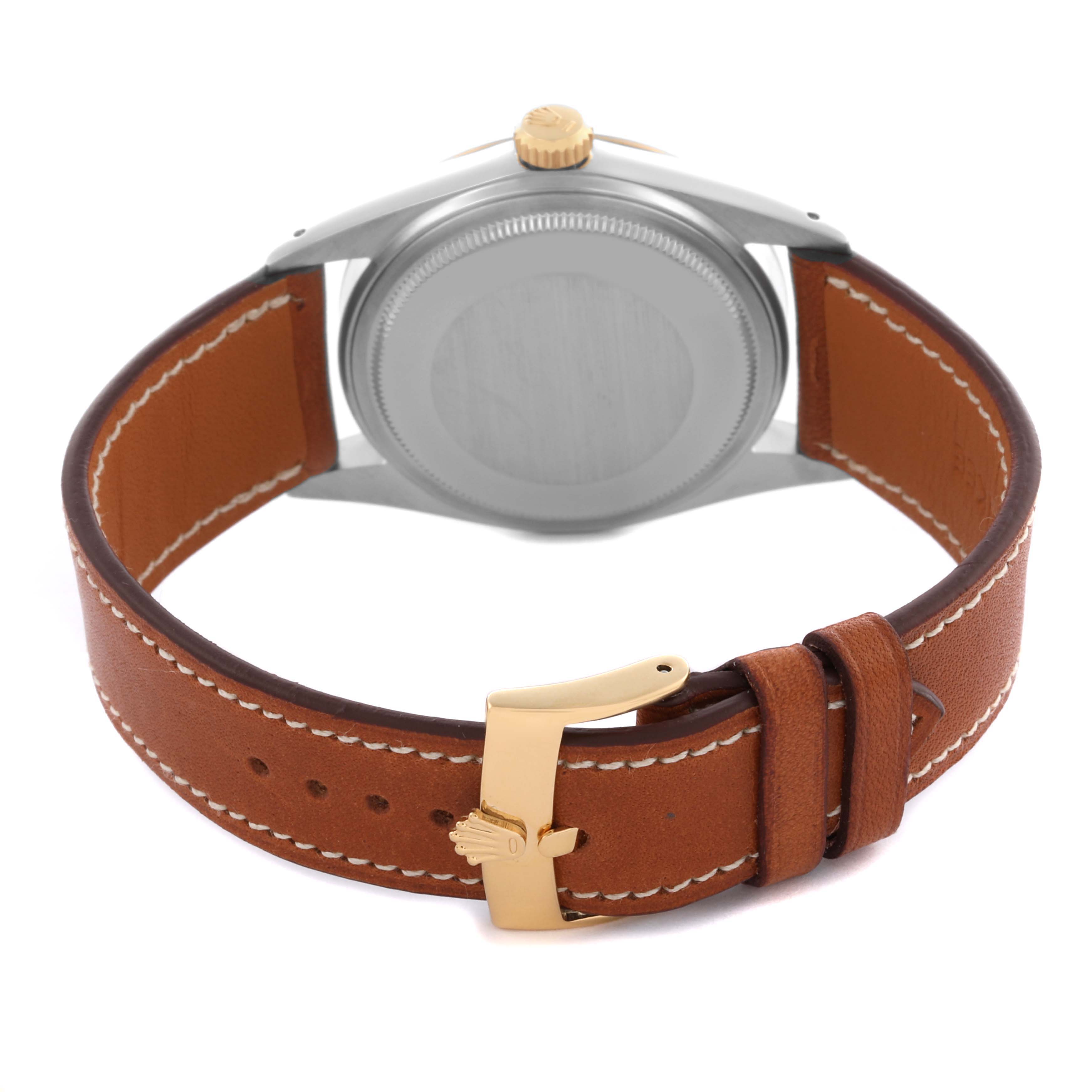 The image shows the back of a Rolex Datejust 16013 Men's Steel and Gold (two tone) Champagne Dial 16013 Men's Steel and Gold (two tone) Champagne Dial watch with a leather strap and a gold buckle.