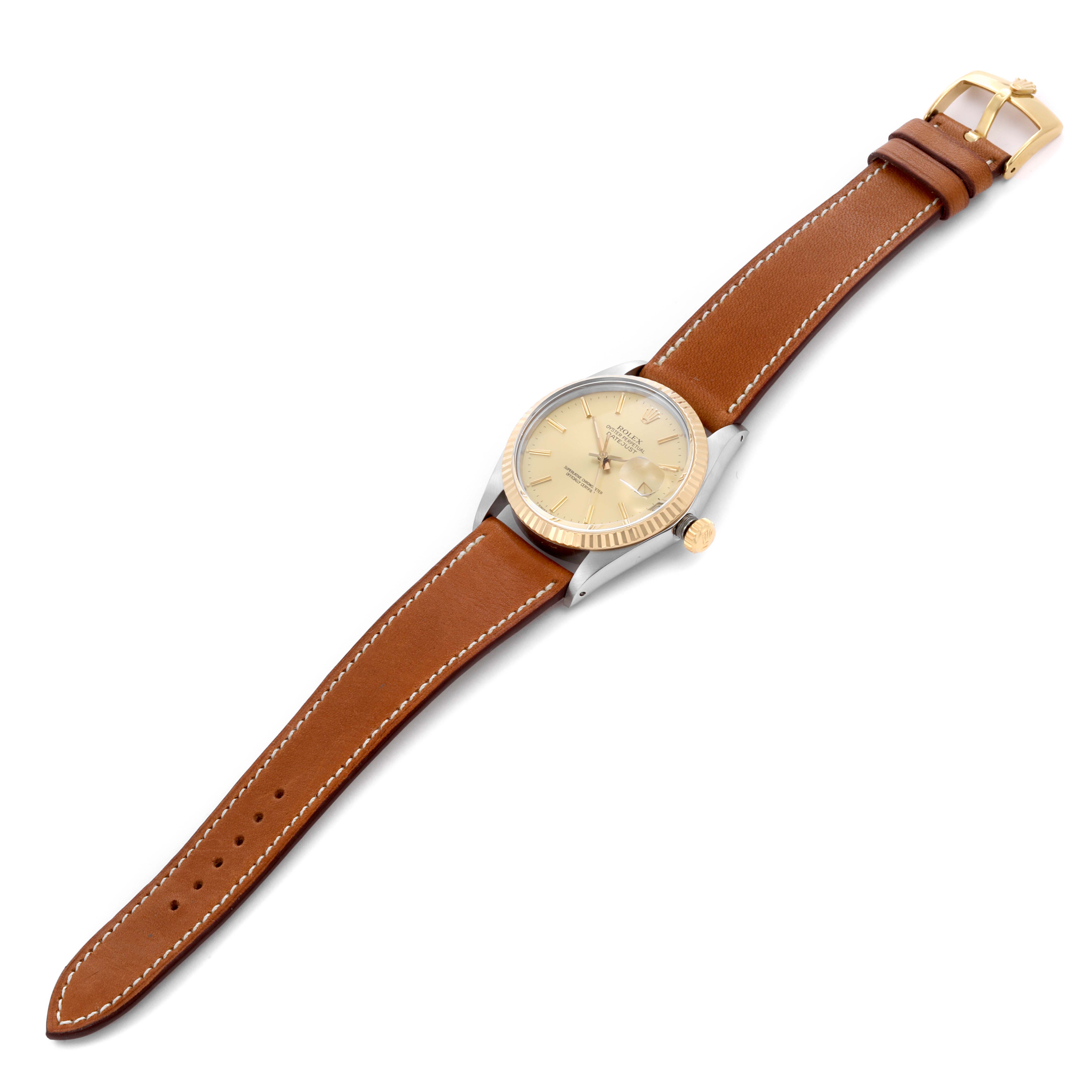 The Rolex Datejust 16013 Men's Steel and Gold (two tone) Champagne Dial 16013 Men's Steel and Gold (two tone) Champagne Dial watch is shown at an angle displaying the watch face, case, crown, and its brown leather strap.