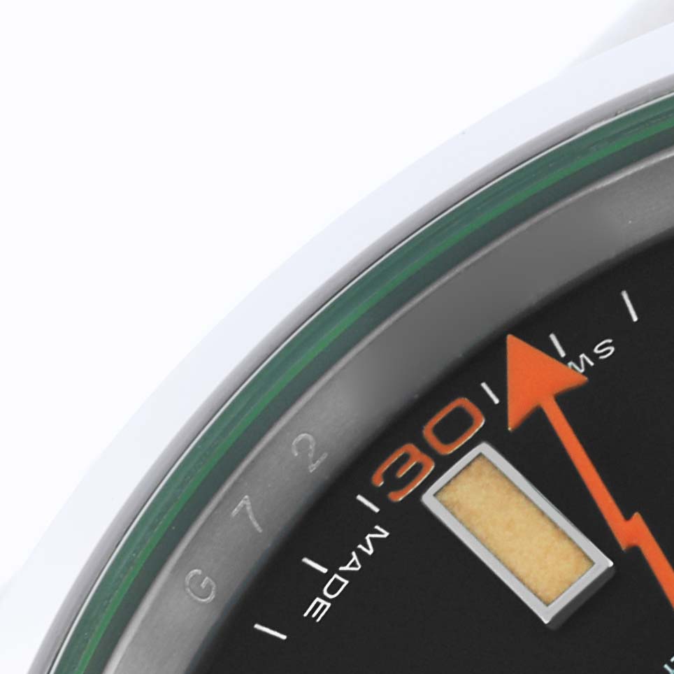 The close-up image shows the Milgauss by Rolex dial's edge, highlighting the orange seconds hand and minute marker details.