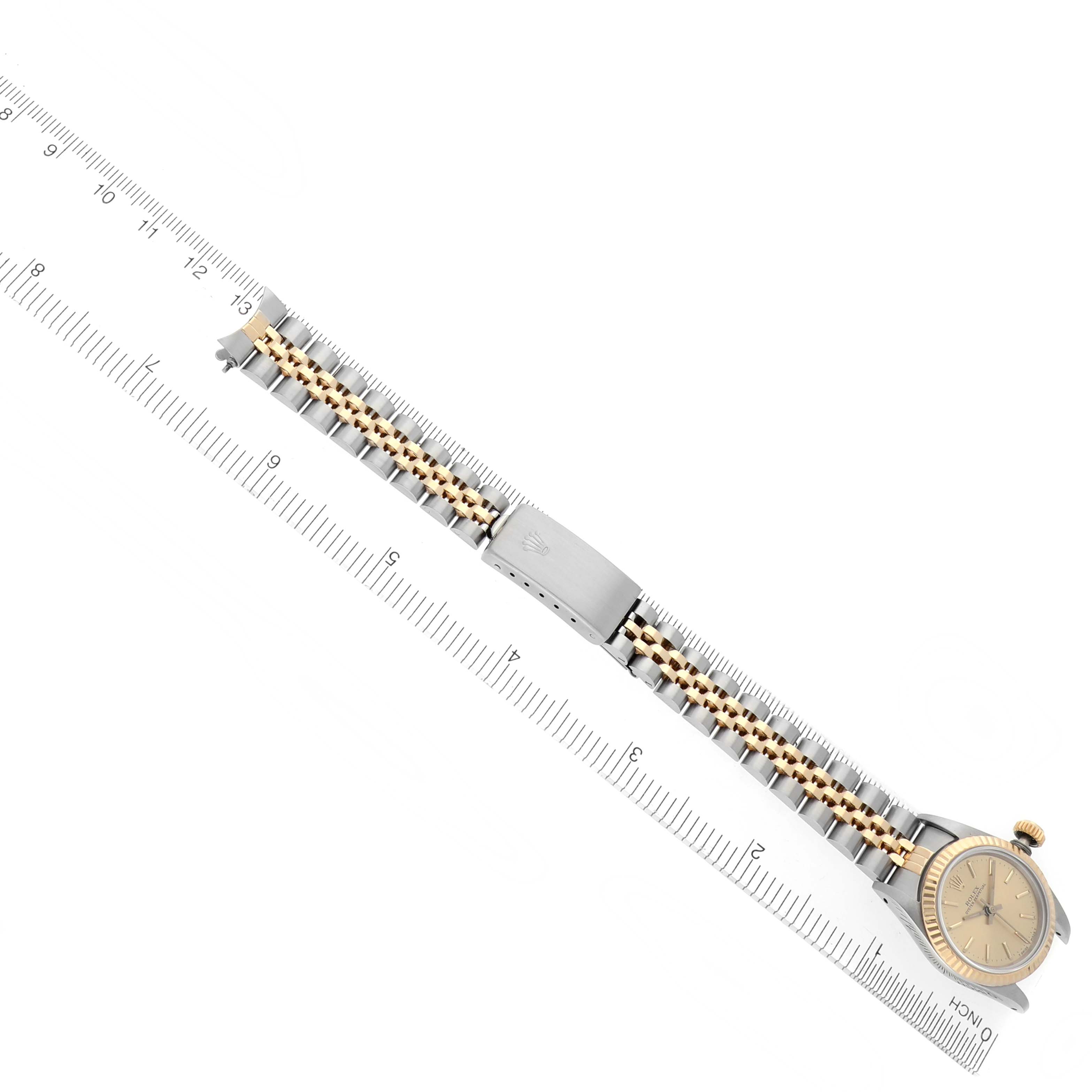 The image shows a Rolex Oyster Perpetual 67193 Women's Steel and Gold (two tone) Champagne Dial 67193 Women's Steel and Gold (two tone) Champagne Dial watch laid flat, highlighting the bracelet and clasp with a ruler for scale.