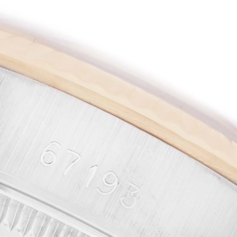 The image shows a close-up of the Rolex Oyster Perpetual 67193 Women's Steel and Gold (two tone) Champagne Dial 67193 Women's Steel and Gold (two tone) Champagne Dial watch's serial number engraved on the case side.