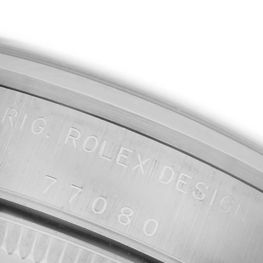 The image shows a close-up of the case back edge of a Rolex Mid-Size 77080 Women's Stainless Steel Silver Dial 77080 Women's Stainless Steel Silver Dial model, highlighting the engraved serial and design numbers.