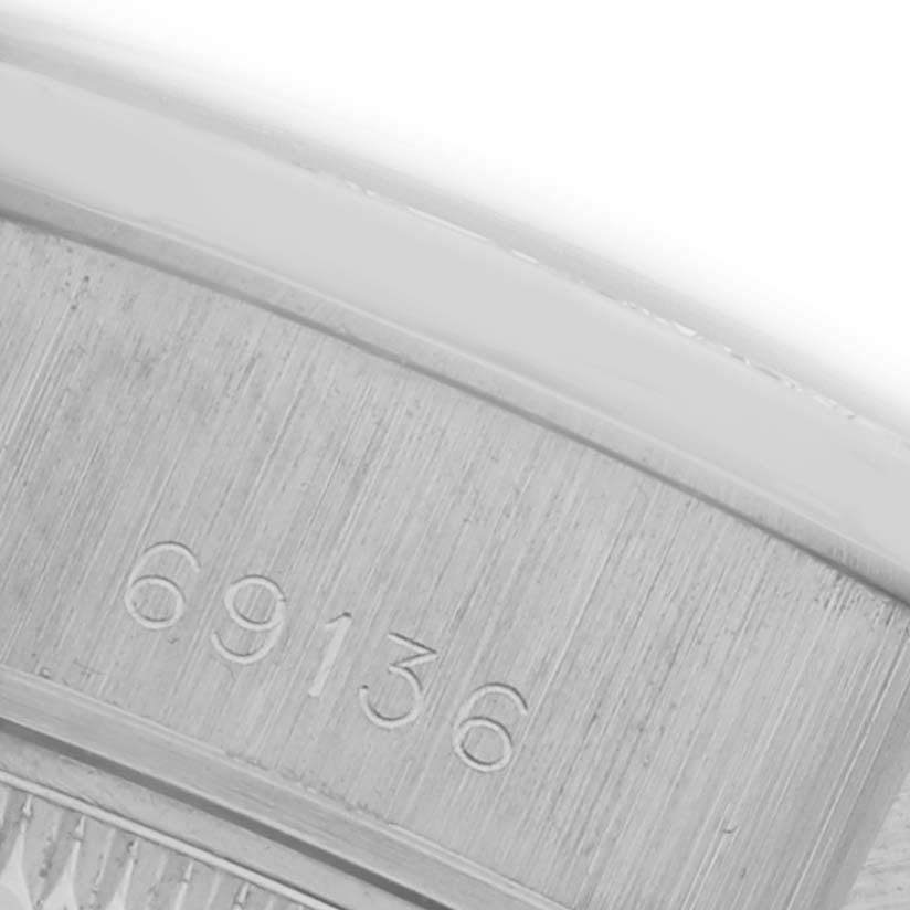 The image shows the side view of a Rolex President 69136 Women's Platinum Silver Dial 69136 Women's Platinum Silver Dial model watch, focusing on its engraved serial number.