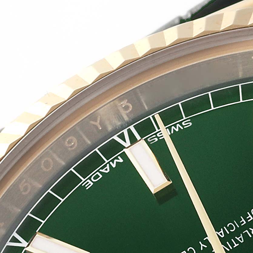 This close-up image shows the bezel and part of the dial of a Rolex President 118138 Men's Yellow Gold Green Dial 118138 Men's Yellow Gold Green Dial model watch.
