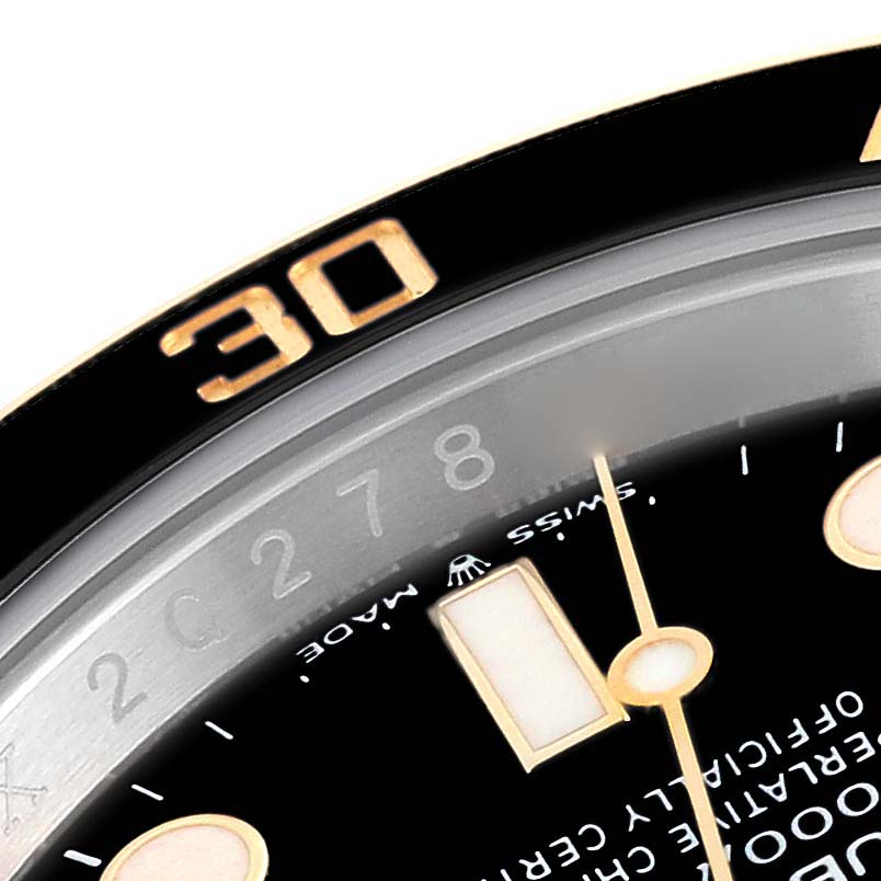 The image shows a close-up of the bezel, minute hand, and part of the dial of a Rolex Submariner 126613LN Men
s Steel and Gold (two tone) Black Dial 126613LN Men
s Steel and Gold (two tone) Black Dial watch.