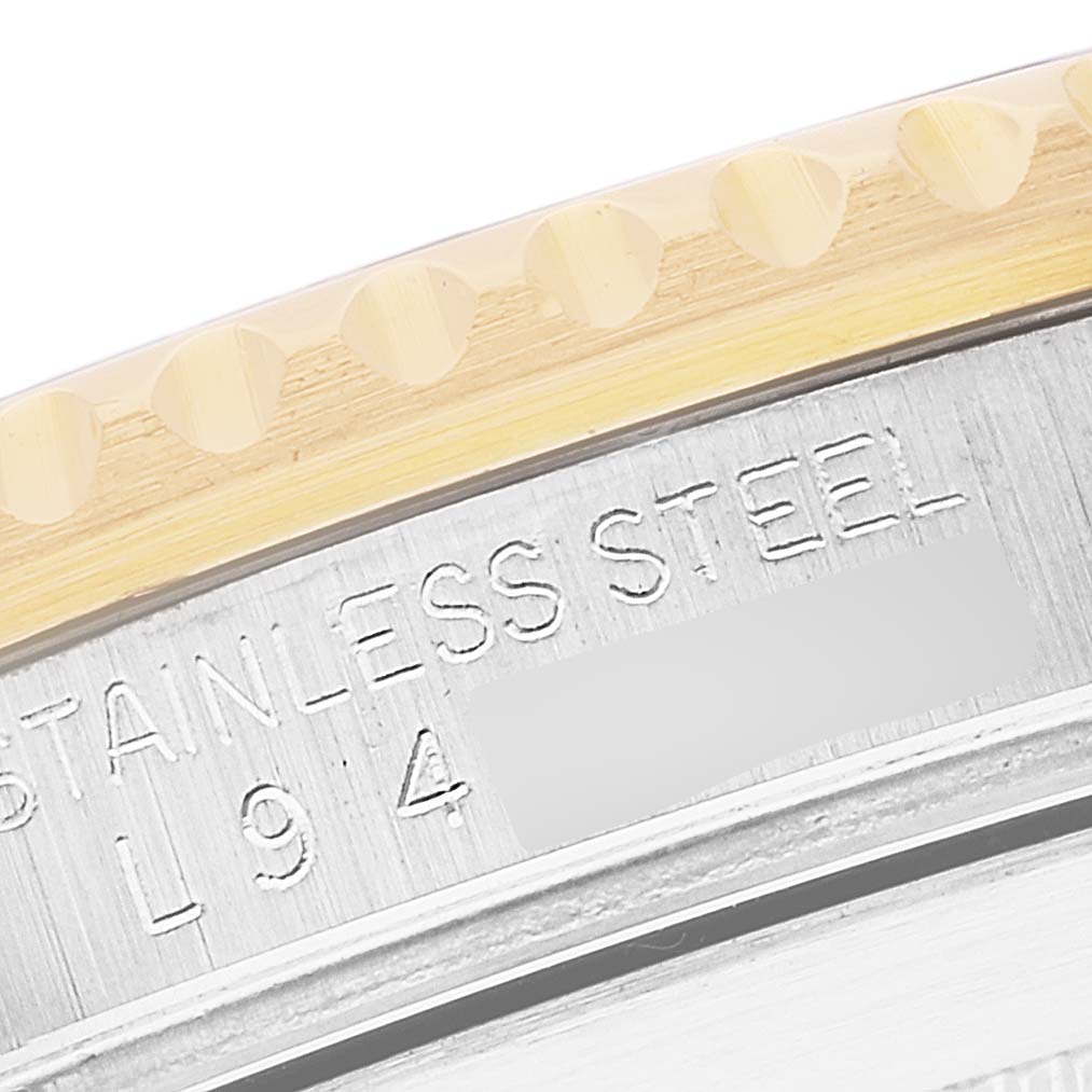 This close-up image shows the engraved stainless steel side of a Rolex Submariner 16613 Men's Steel and Gold (two tone) Blue Dial 16613 Men's Steel and Gold (two tone) Blue Dial model, including part of its bezel.