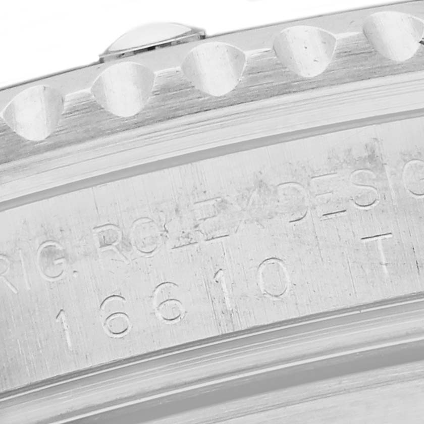 The image shows a close-up of the engraved side of a Rolex Submariner 16610 Men's Stainless Steel Black Dial 16610 Men's Stainless Steel Black Dial bezel and case.