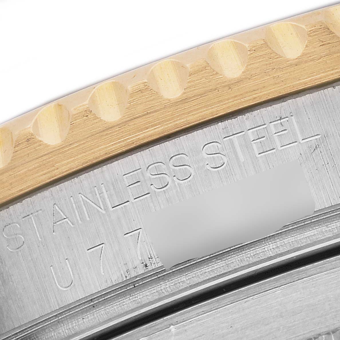 The image shows a close-up of the bezel and engraved text on the back case of a Rolex Submariner 16613 Men
s Steel and Gold (two tone) Black Dial 16613 Men
s Steel and Gold (two tone) Black Dial watch.