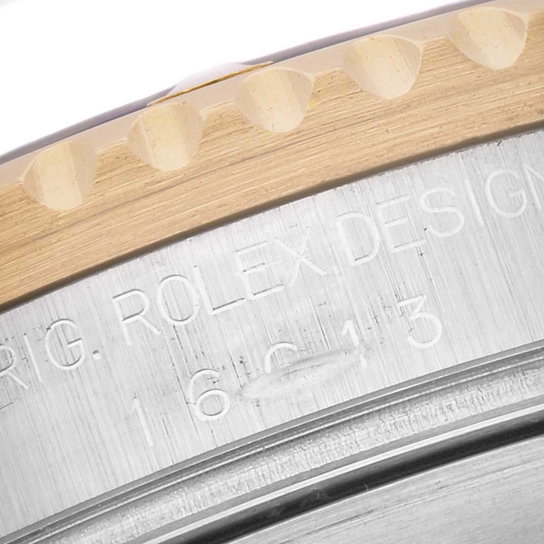 This close-up image shows the engraved edge and bezel of a Rolex Submariner 16613 Men
s Steel and Gold (two tone) Black Dial 16613 Men
s Steel and Gold (two tone) Black Dial watch.
