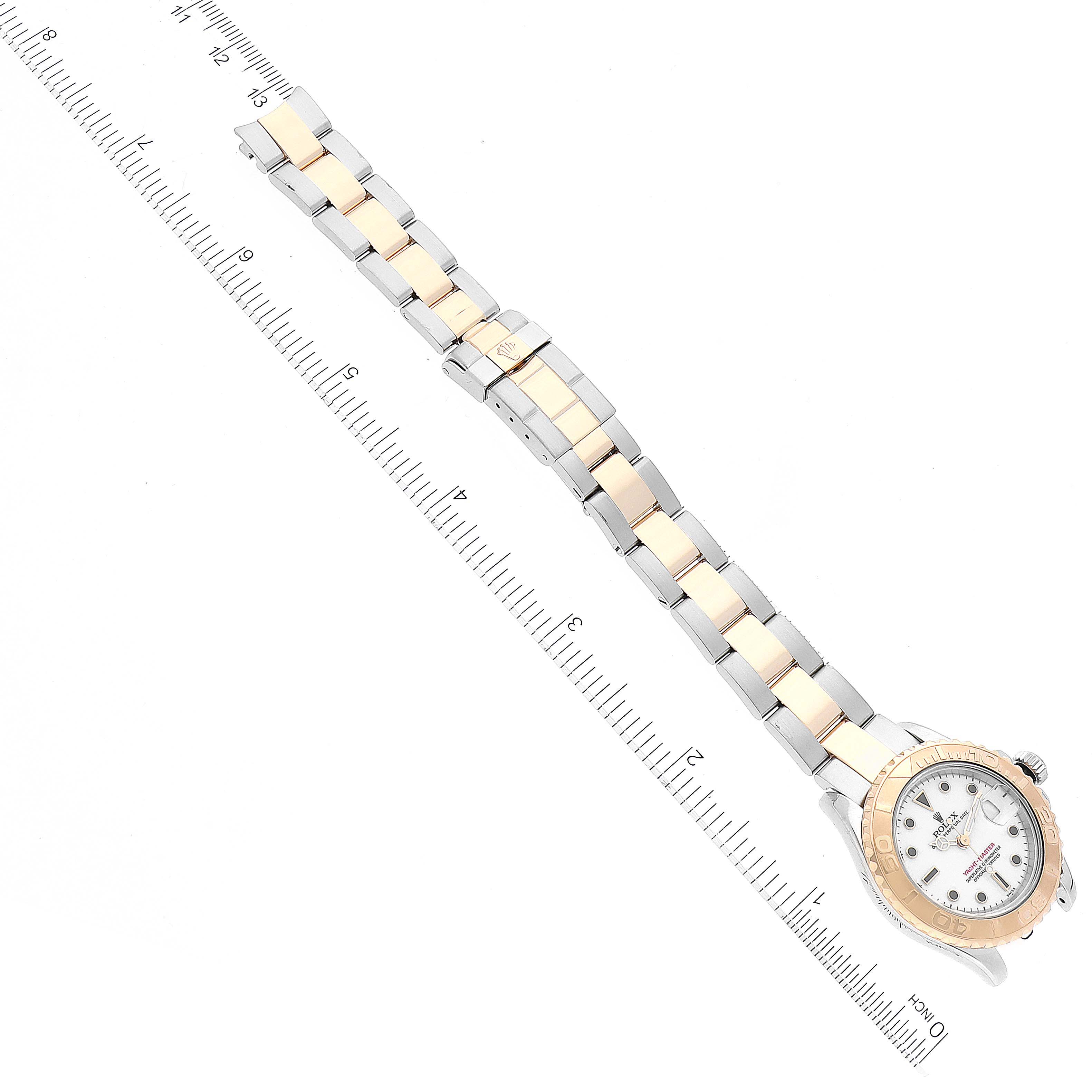 The image shows a Rolex Yacht-Master 169623 Women's Steel and Gold (two tone) White Dial 169623 Women's Steel and Gold (two tone) White Dial watch laid flat with its band, positioned diagonally against a ruled background for measurement.
