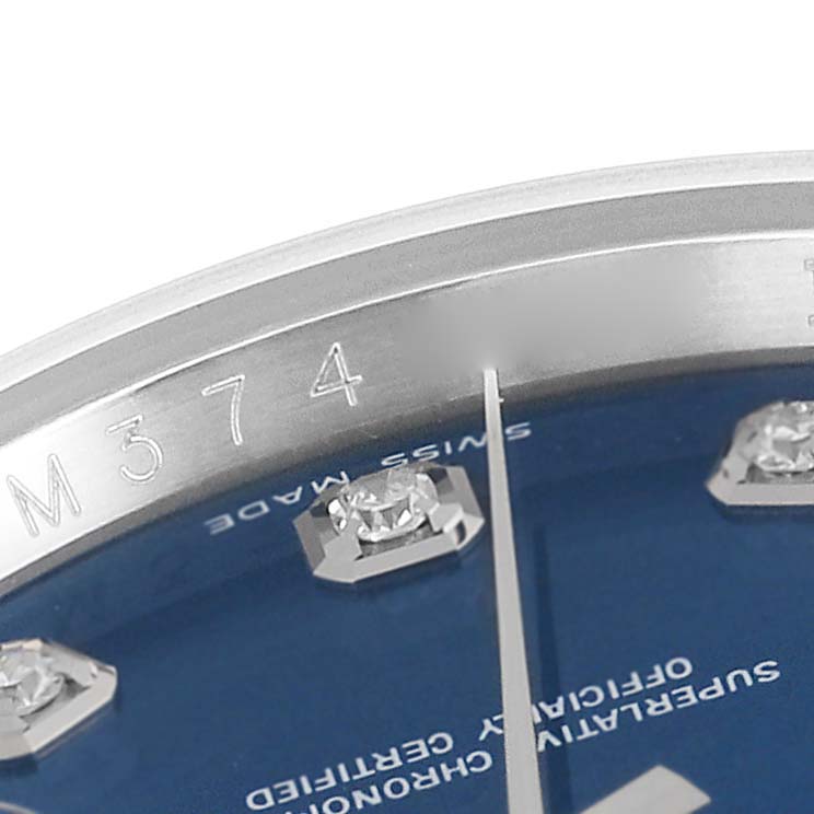 The image shows a close-up of the dial and bezel of a Rolex Datejust 116234 Men's Stainless Steel Blue Dial 116234 Men's Stainless Steel Blue Dial watch, featuring diamond markers and a blue dial.