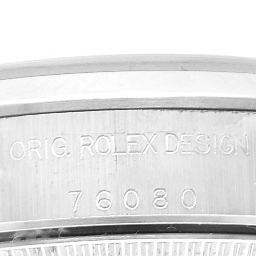 This image shows a close-up of the case back edge of a Rolex Oyster Perpetual 76080 Women's Stainless Steel Black Dial 76080 Women's Stainless Steel Black Dial watch, highlighting the engraved model and brand details.