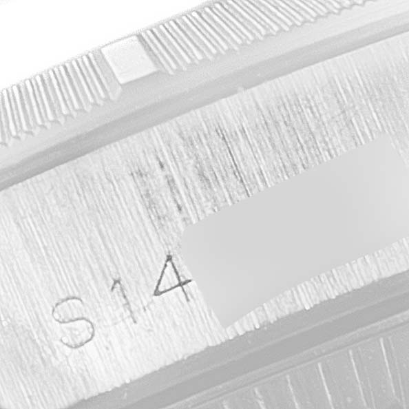 This image shows a close-up of the engravings on the case back edge of a Rolex Oyster Perpetual 67230 Women's Stainless Steel Black Dial 67230 Women's Stainless Steel Black Dial watch.