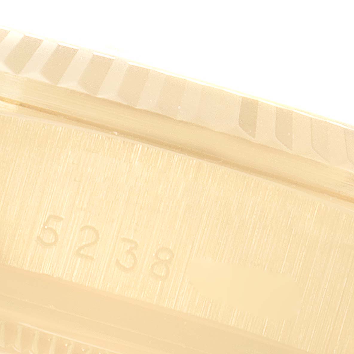 This close-up image shows the lower right side of the bezel and part of the case of a President model by Rolex, including the serial number.