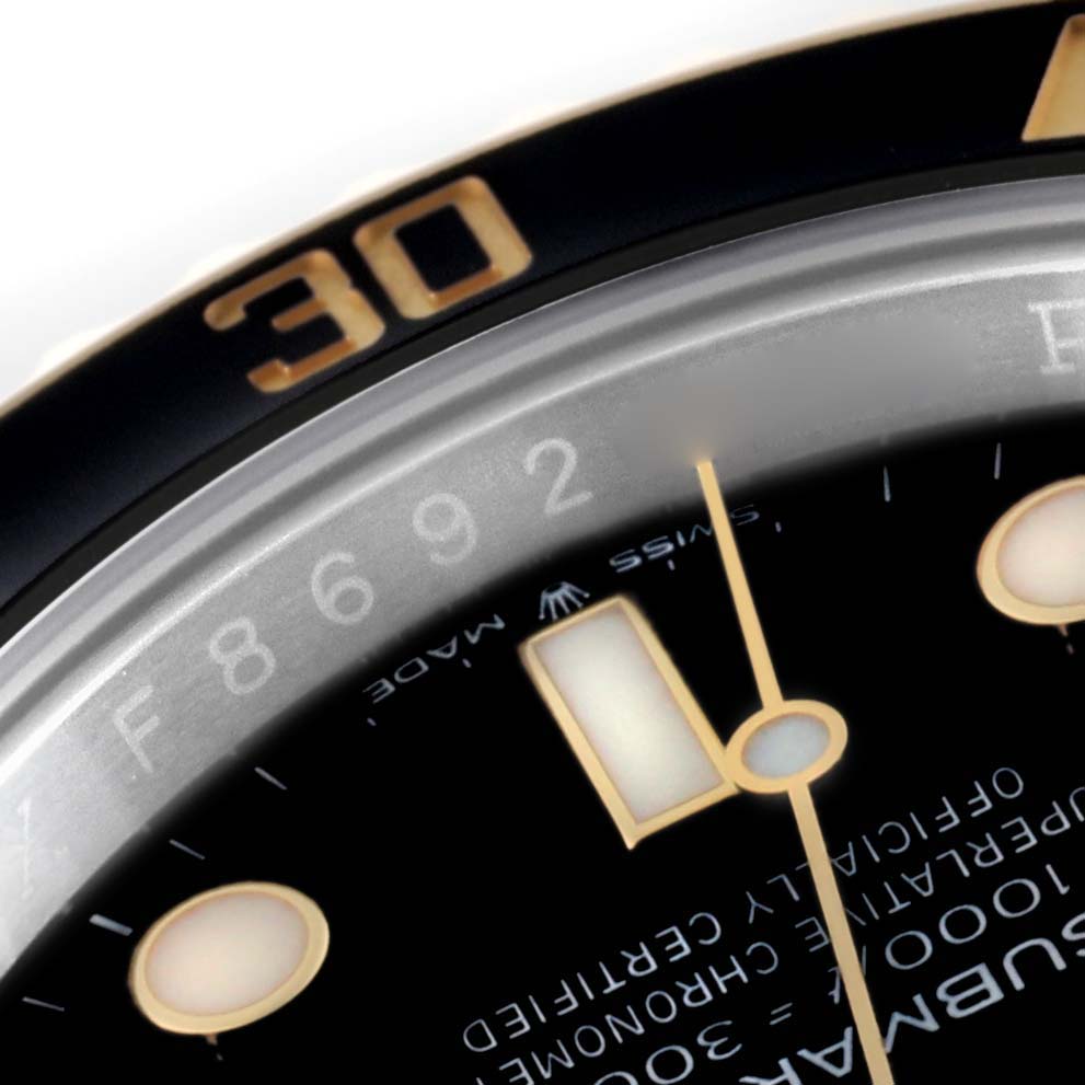 This image shows a close-up of the bezel, dial, and minute hand of a Rolex Submariner 126613LN Men's Steel and Gold (two tone) Black Dial 126613LN Men's Steel and Gold (two tone) Black Dial watch.