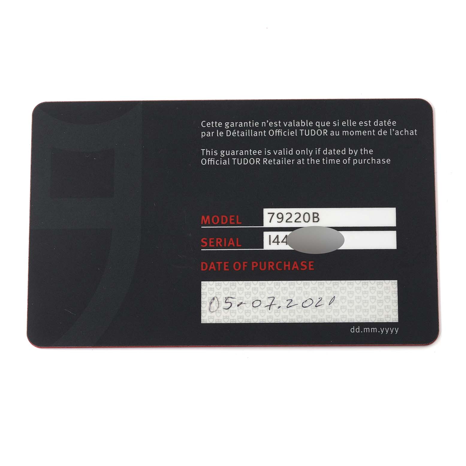This image shows a warranty card for the Tudor Heritage Black Bay 79220B Men
s Stainless Steel Black Dial 79220B Men
s Stainless Steel Black Dial model 79220B, with the purchase date and serial number partially obscured.