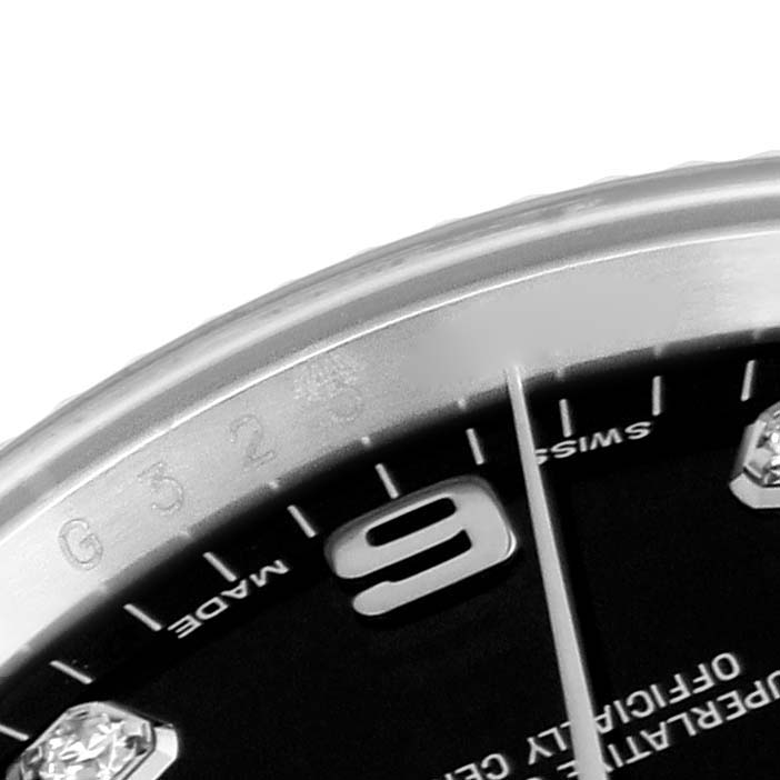 The image shows a close-up of the dial and bezel of a Rolex Date 115234 Men's Stainless Steel Black Dial 115234 Men's Stainless Steel Black Dial model, focusing on the 9 o'clock area.