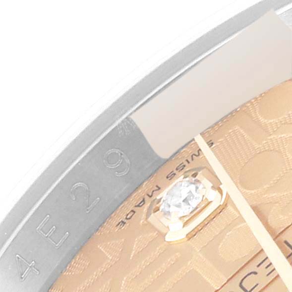 The image shows a close-up of the dial and bezel of a Rolex Datejust 116243 Men's Steel and Gold (two tone) Champagne Dial 116243 Men's Steel and Gold (two tone) Champagne Dial watch with some markings and a diamond.