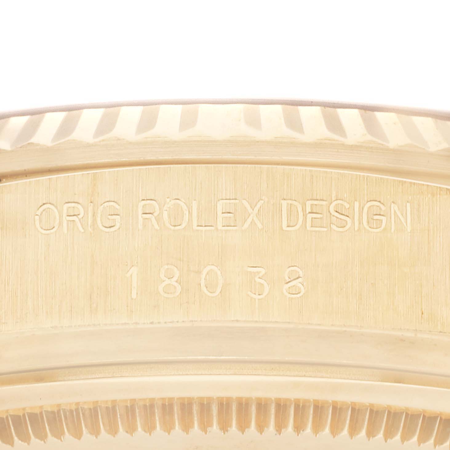 The image shows a close-up of the case side of the Rolex President 18038 Men
s Yellow Gold Champagne Dial 18038 Men
s Yellow Gold Champagne Dial model watch, displaying its engraving "ORIG ROLEX DESIGN 18038".
