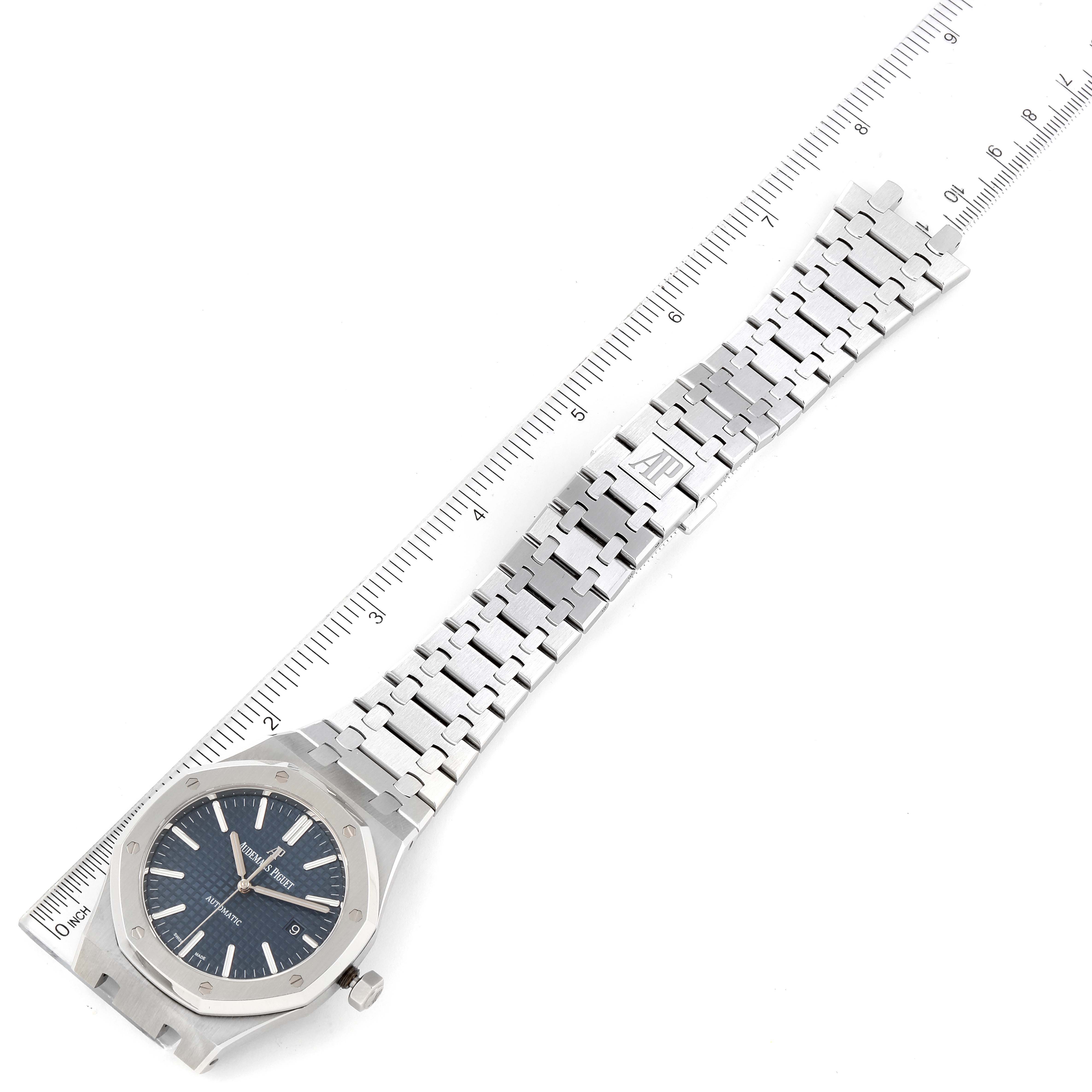 The image shows a flat-laid Audemars Piguet Royal Oak 15400ST.OO.1220ST.03 Men's Stainless Steel Blue Dial 15400ST.OO.1220ST.03 Men's Stainless Steel Blue Dial watch, displaying its case, dial, crown, and stainless steel bracelet with a ruler for scale.